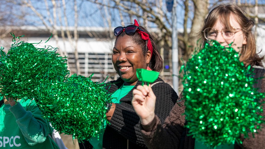 Two people with green glitter pompoms