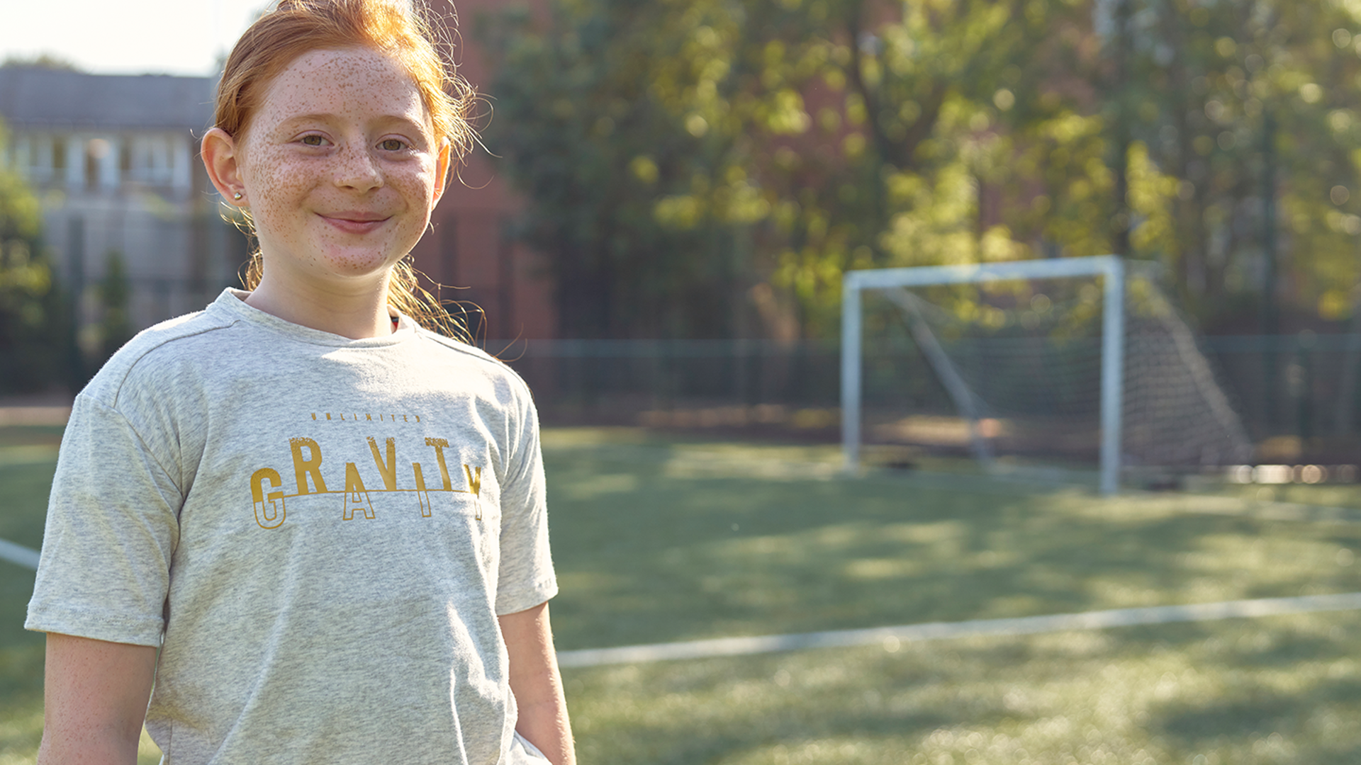 girl stood in front of football goal